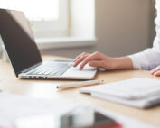 Die Hände einer Frau, die auf einem Macbook tippt